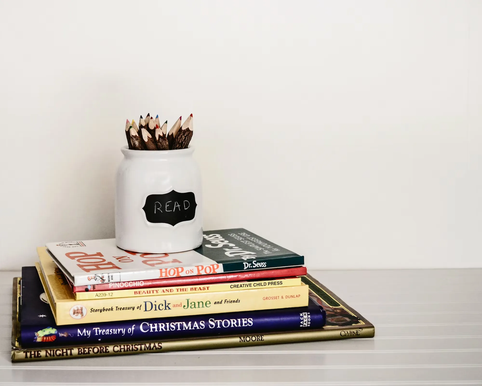 

An image of a stack of classic children's books, with a few of the books open to reveal colorful illustrations, set against a white background. The image conveys the timelessness of classic children's literature, and the joy of discovering these